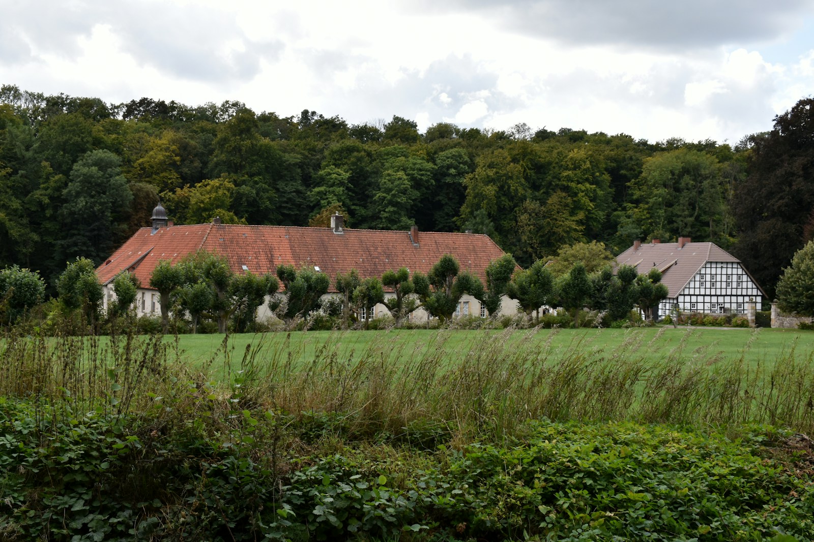 Hofgebäude eines landwirtschaftlichen Betriebs, umgeben von Grünflächen